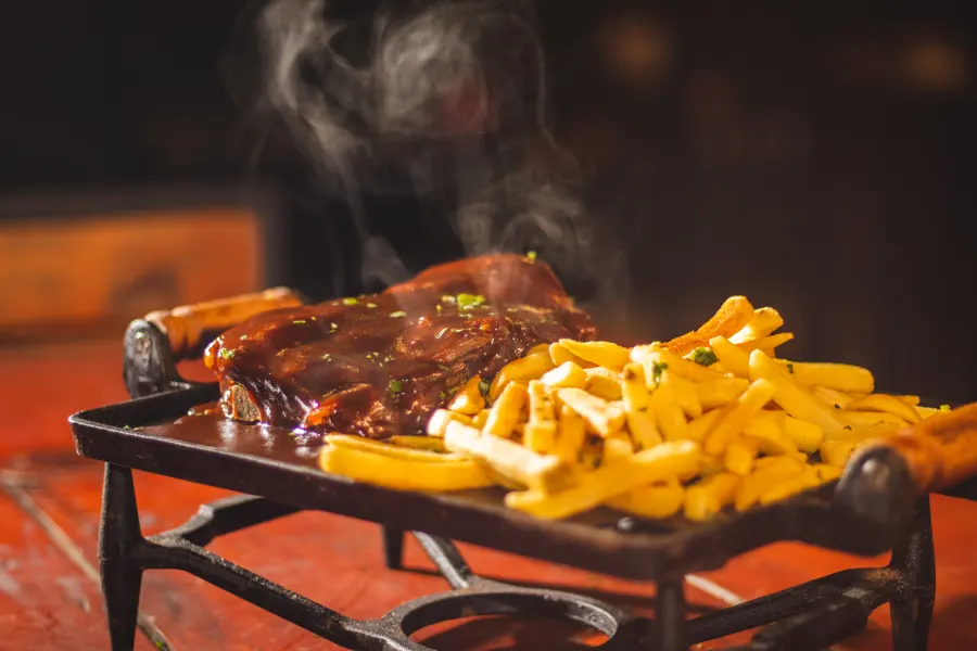 Costela com fritas soltando fumaça na chapa