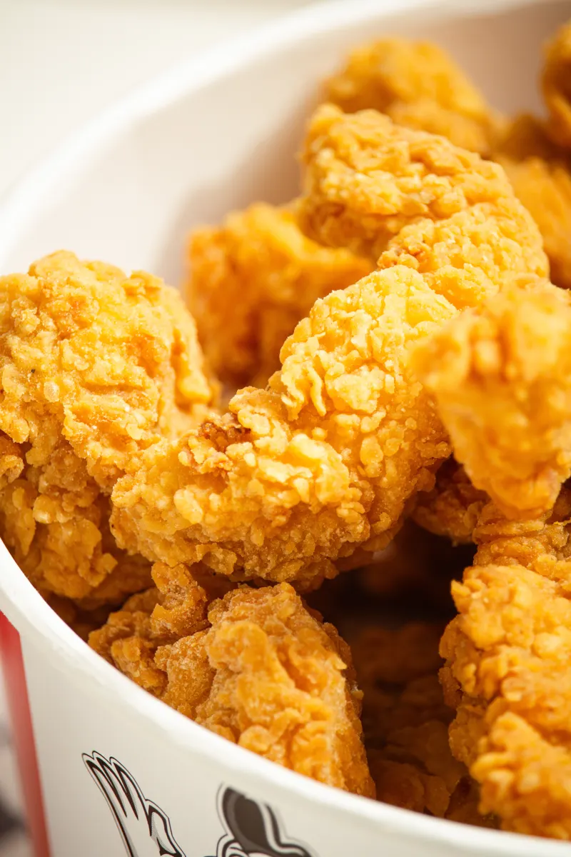 Close do balde de frango frito crocante