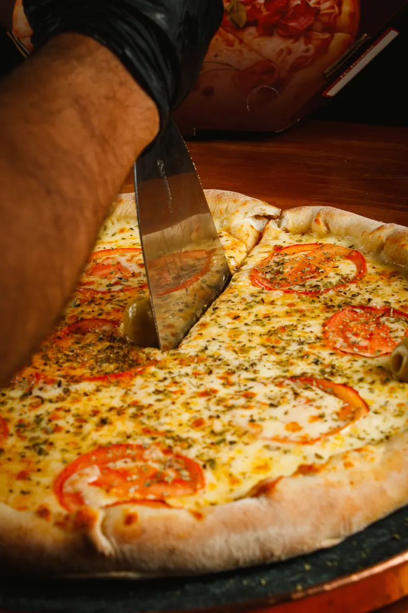 Espátula cortando pizza de mussarela