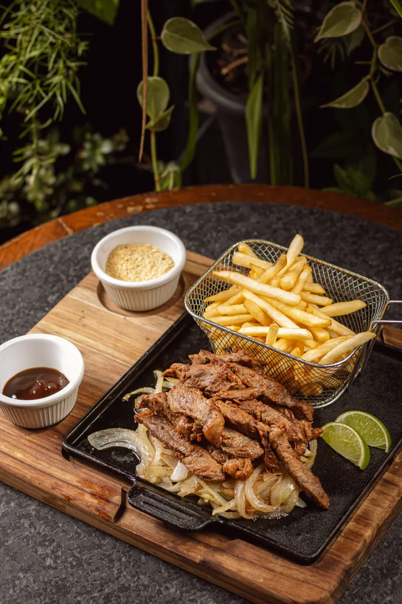 Carne salteada com fritas e limão servida em tábua no Garuda Gastrobar